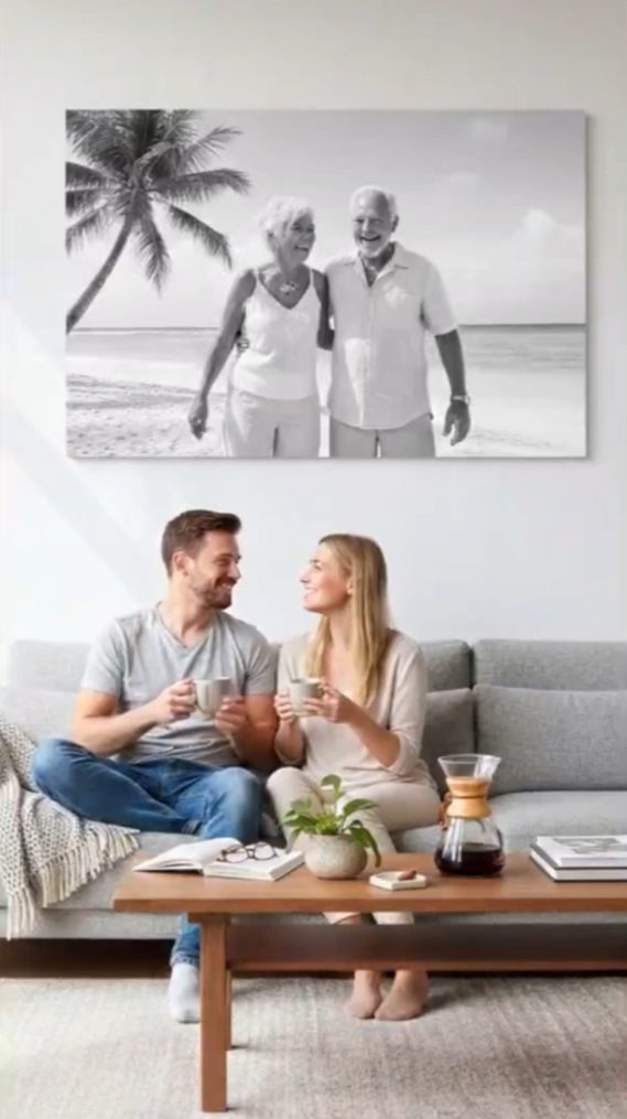 Pareja conversando en un sofá, con una foto en blanco y negro de dos hombres en la pared.